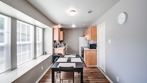 A compact kitchen with wooden cabinets, a microwave, and a refrigerator.