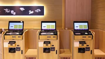 Uma fileira de quiosques de madeira com laptops exibindo cardápios, provavelmente para serviços de autoatendimento.