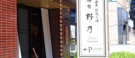 Entrada de un hotel con un letrero que indica un dormitorio estilo japonés.