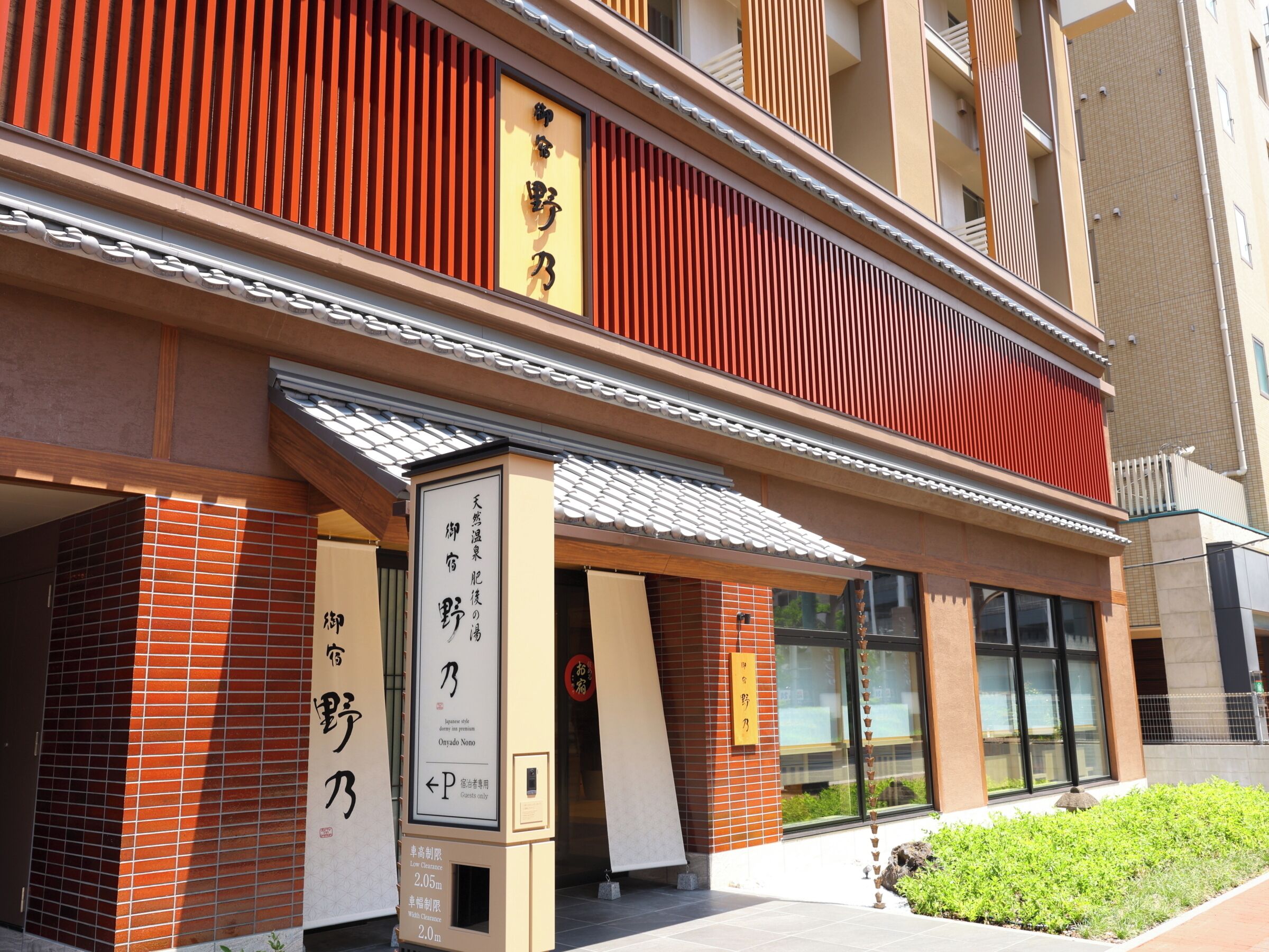 A building with traditional Japanese architecture, including a red wooden facade and a tiled entrance.