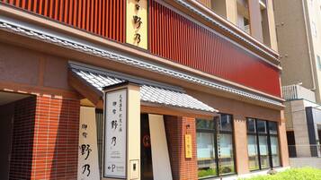 A building with traditional Japanese architecture, including a red wooden facade and a tiled entrance.