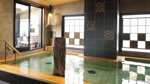 An indoor swimming pool with a wooden floor, tiled walls, and a large window. - Natural Hot Spring Higo no Yu Onyado Nono Kumamoto (Kumamoto)