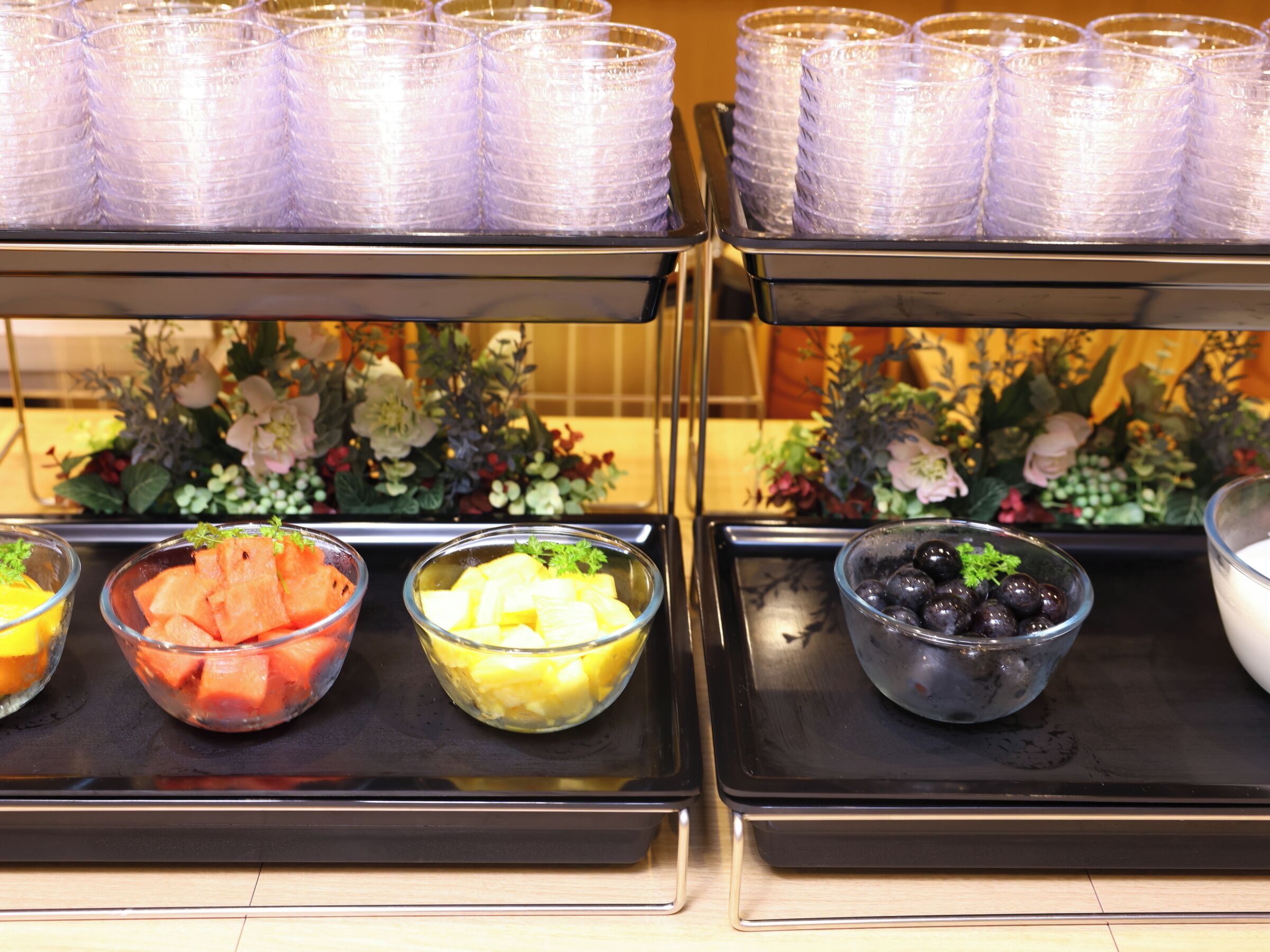 Un buffet proposant une variété de plats, notamment de la pastèque, de l’ananas et des mûres.