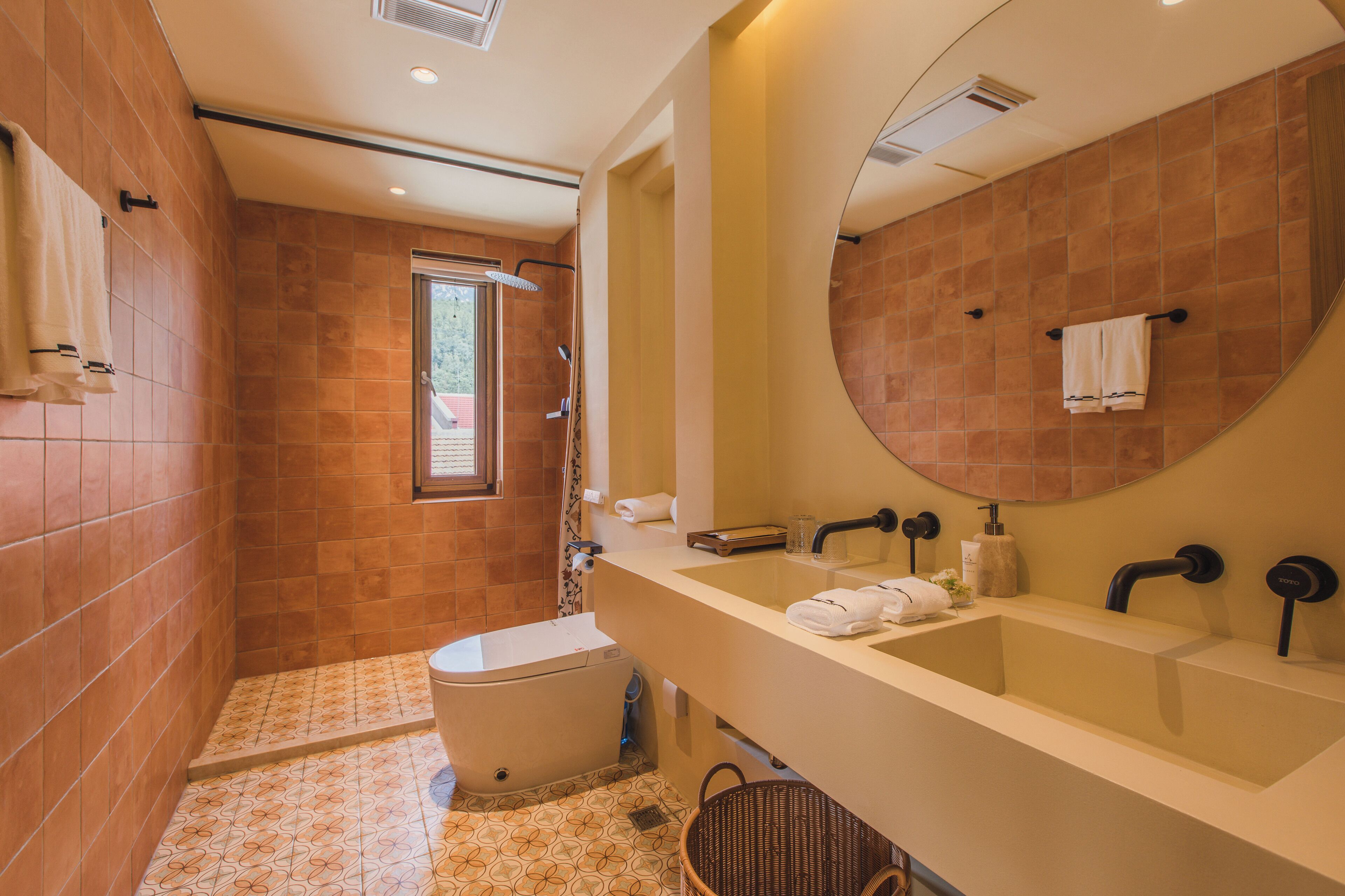 Ein modernes Badezimmer mit einem großen Spiegel, zwei Waschbecken und einer Dusche.