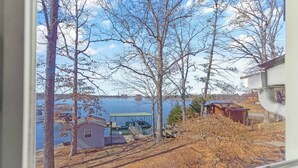 Järvenrantatontti, jossa on laituri, pieni mökki ja katettu alue, josta veneen voi laskea veteen.