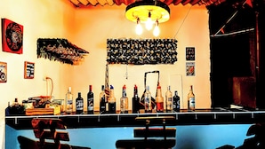 Un bar con diverse bottiglie e una lavagna con il menu.
