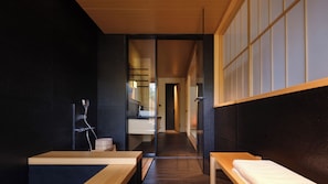 Een moderne badkamer met een houten bankje, een wastafel en een spiegel.