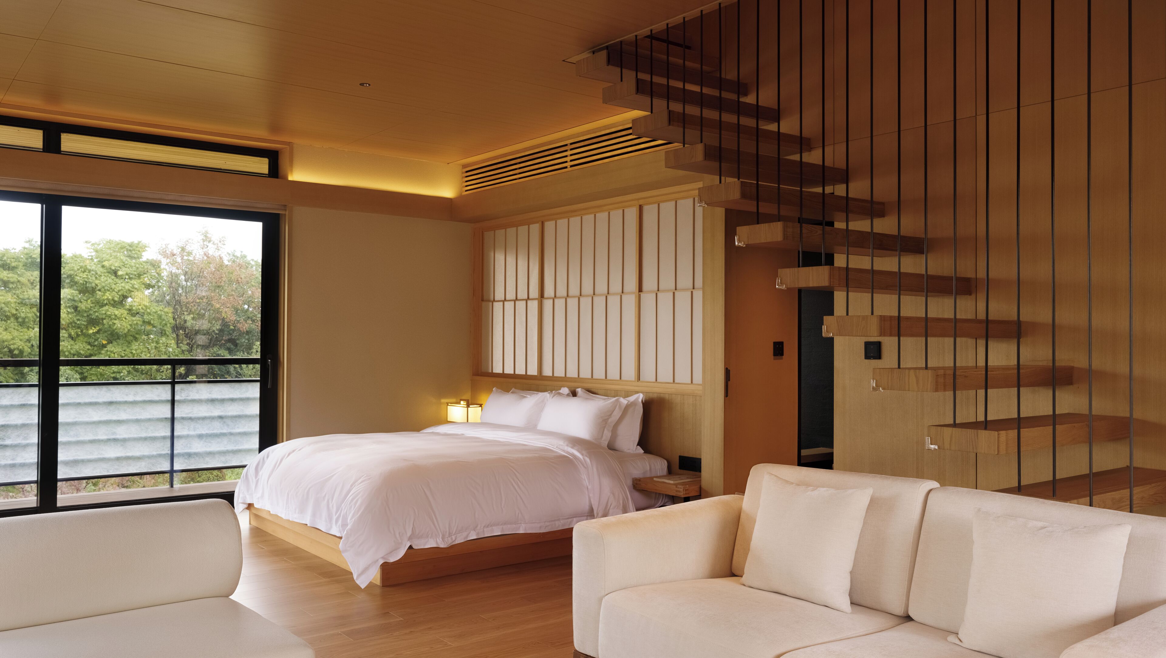 Un dormitorio moderno con una cama grande, un sofá y una escalera.