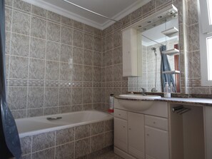 A bathroom with a bathtub, a sink, and a mirror. - Erisa 2, 28 - Terrace, Swimming Pool, Parking, Second line of beach. 2 bedrooms (Torremolinos)
