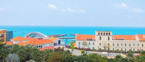 Paesaggio costiero urbano con edifici, un ponte e il mare.