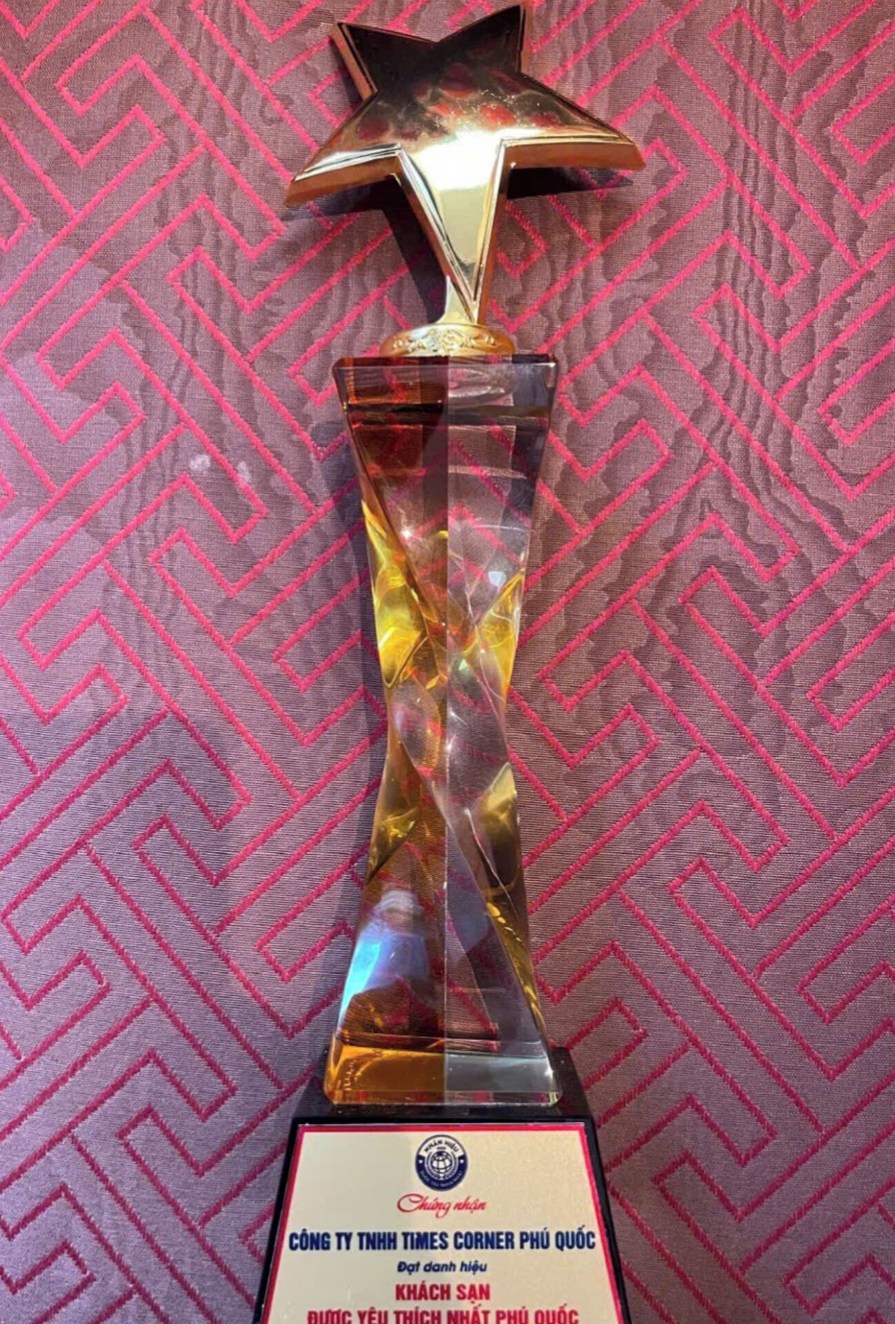 A trophy with a star on top, placed on a stand with a plaque at the base.