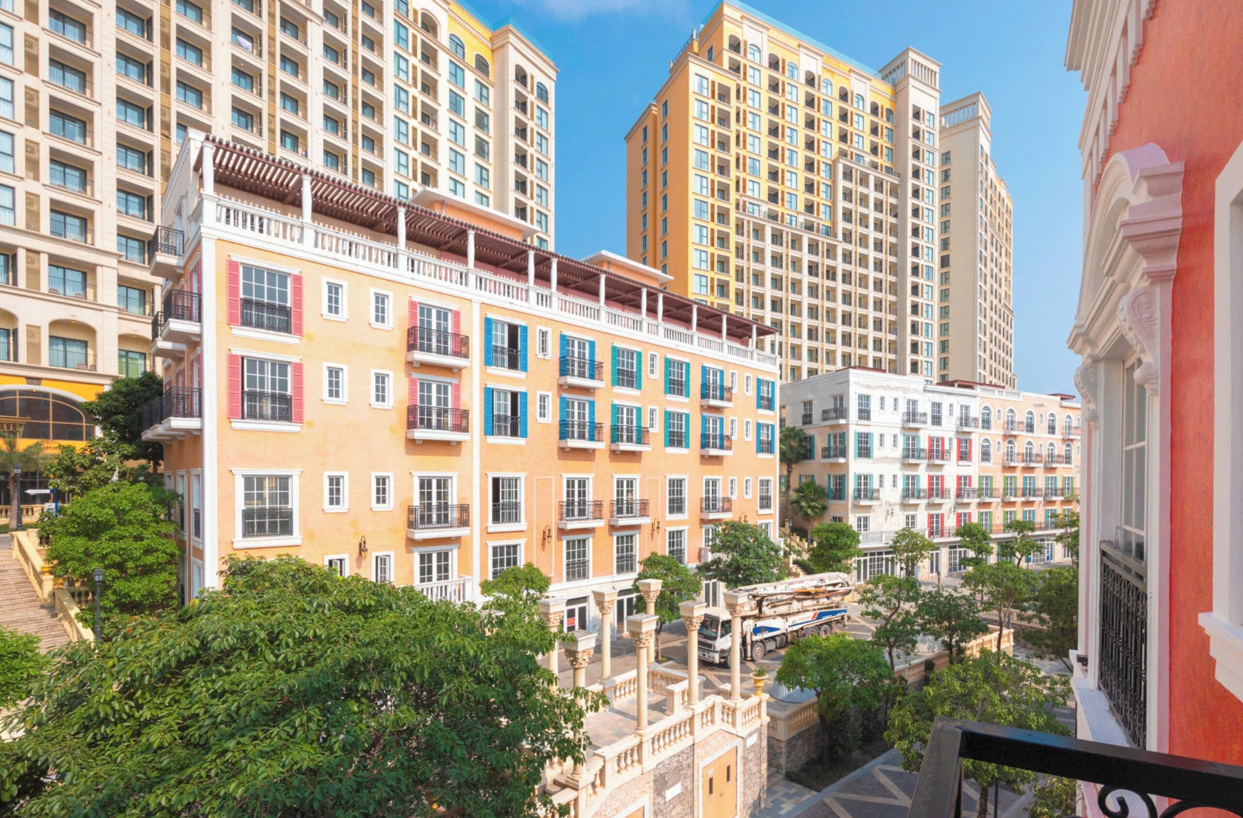 A multi-story hotel with balconies, a courtyard, and a view of other buildings.