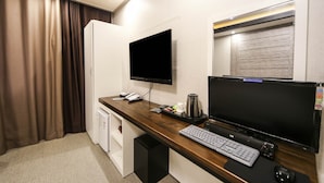 A hotel room with a wooden desk, a flat-screen TV, a desktop computer, a telephone, and a coffee maker. - hotel gyeryong (Gyeryong)