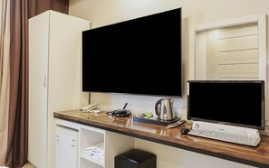 A hotel room with a desk, a flat-screen TV, a laptop, a kettle, and a cabinet. - hotel gyeryong (Gyeryong)