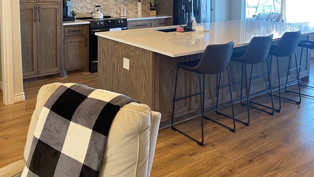 Een moderne keuken met houten kastjes, een centraal eiland en hanglampen.