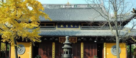 Un bâtiment traditionnel avec un toit en tuiles, une lanterne centrale et une enseigne.