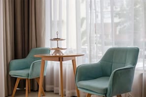 A room with two teal armchairs and a small wooden table with a decorative item. - GreenTree Smart Choice Hotel (Shanghai Chest hospital Hongqiao Road Metro Station) (Shanghai)