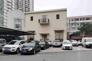 A parking lot with multiple cars and a building with balconies.