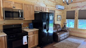 Una cocina con armarios de madera, un refrigerador de acero inoxidable, un microondas y una estufa.