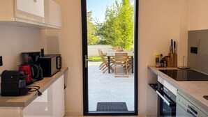 Cuina moderna amb una porta corredissa que dona a un espai exterior amb terrassa.