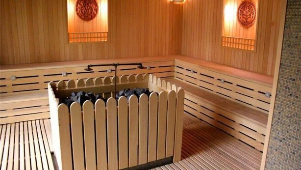 A sauna with wooden benches and a central heated stone area. - GreenTree Inn Jiangsu Wuxi Jiangyin Yunting Changshan Avenue Chengyang Road Business Hotel (Jiangyin)