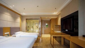 A hotel room with two beds, a desk, a television, and a bathroom visible through a glass door. - GreenTree Inn Jiangsu Wuxi Jiangyin Yunting Changshan Avenue Chengyang Road Business Hotel (Jiangyin)