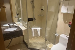 A modern bathroom with a glass-enclosed shower, a sink with a marble countertop, and a toilet.