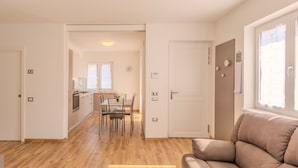A modern apartment with a dining area, kitchen, and living room.