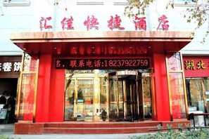 A building with a red facade and a glass entrance. - Huijia Express Hotel (Luoyang)