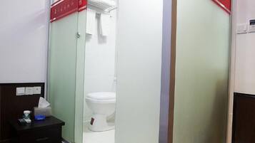Een badkamer met een toilet, een spiegel en een wastafel met een pak tissues.