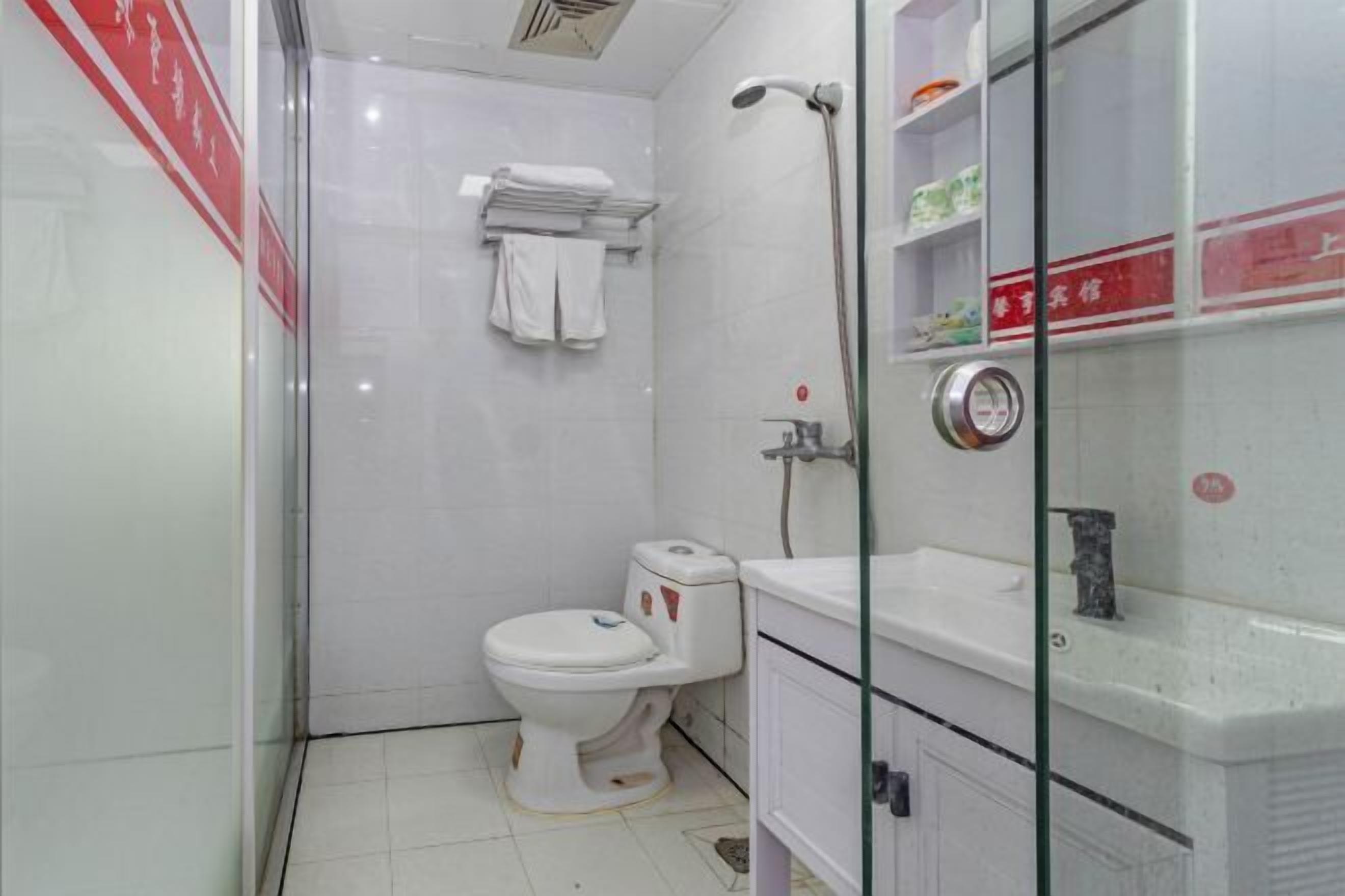 A bathroom with a toilet, a shower, and a sink.