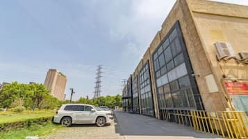 Um edifício com grandes janelas e um carro estacionado na rua.