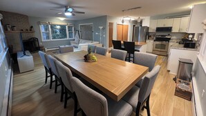 Een moderne keuken met een houten eettafel, grijze stoelen en een inbouwoven.