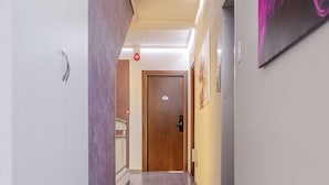 A hallway with a wooden floor, a door at the end, and a wall-mounted artwork. - Hotel 3 Your Haven of Peace in Ventimiglia (Ventimiglia)