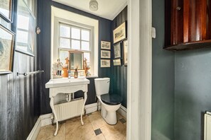 Een badkamer met een wit wastafel, toilet en spiegel.