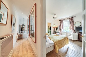 Een hotelkamer met een bed, een dressoir, een televisie en een raam met gordijnen.