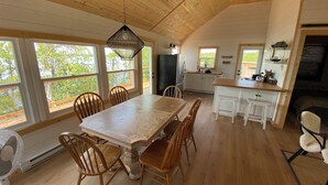 Una cocina amplia con armarios de madera, una isla grande y un comedor con sillas de madera.