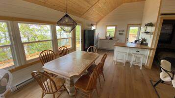 Une cuisine spacieuse dotée de meubles en bois, d’un grand îlot central et d’un coin repas avec des chaises en bois.