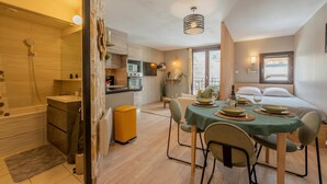 A compact living space with a kitchen, dining area, and a separate bathroom.