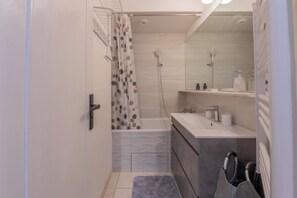 Une petite salle de bain avec une douche, un lavabo et des toilettes.