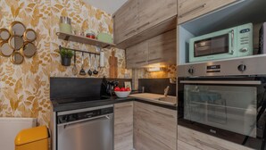 A modern kitchen with wooden cabinets, a dishwasher, a microwave, and a sink.