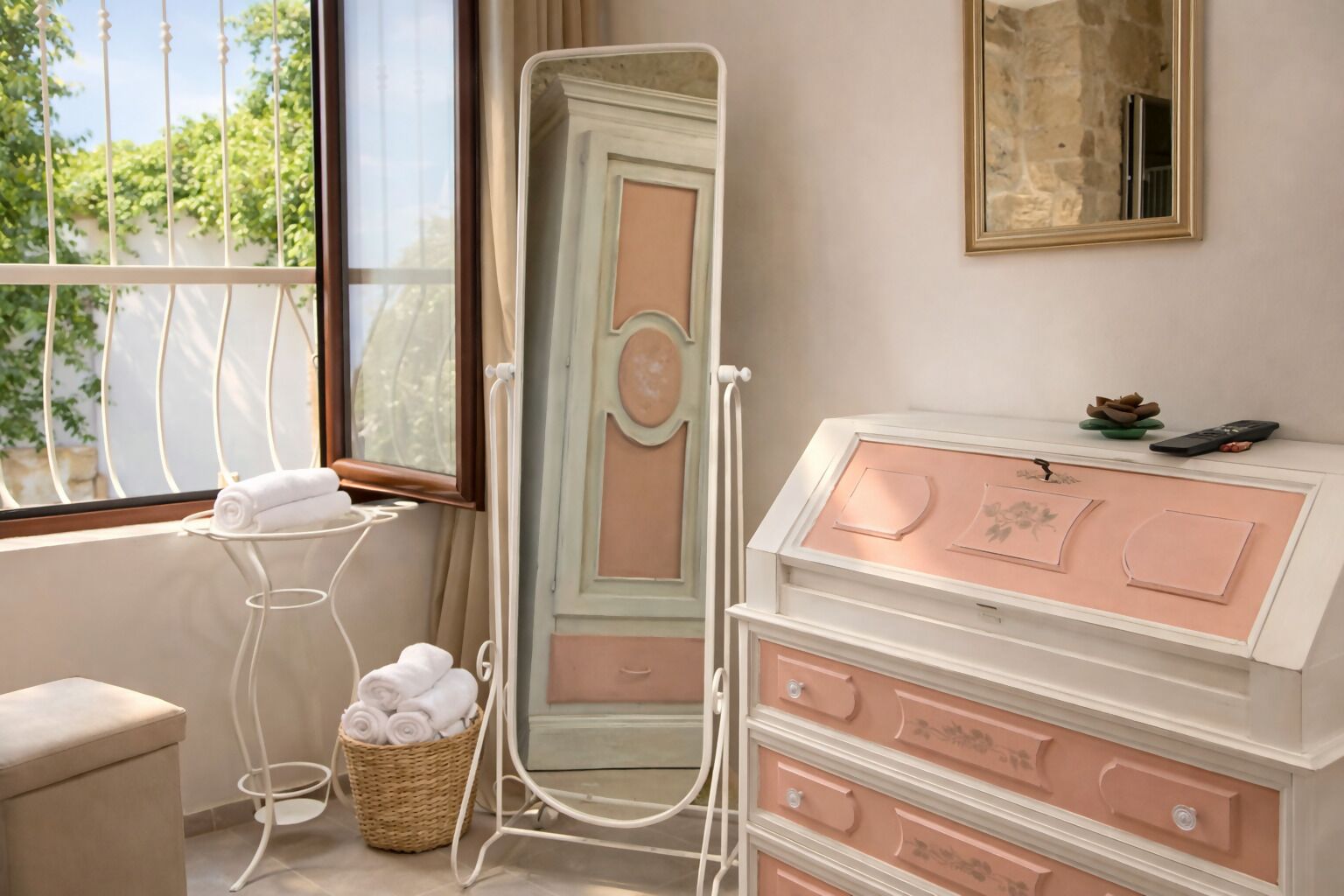 A bathroom with a vanity, a mirror, a towel rack, and a window with a view of greenery.