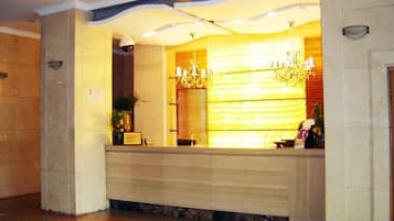 Una recepción con diseño moderno, un candelabro y una planta en maceta.