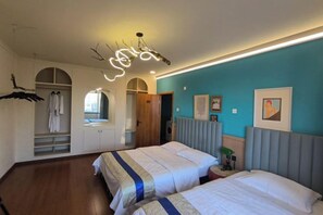 Ein Hotelzimmer mit zwei Betten, einem Kleiderschrank und einem Spiegel.