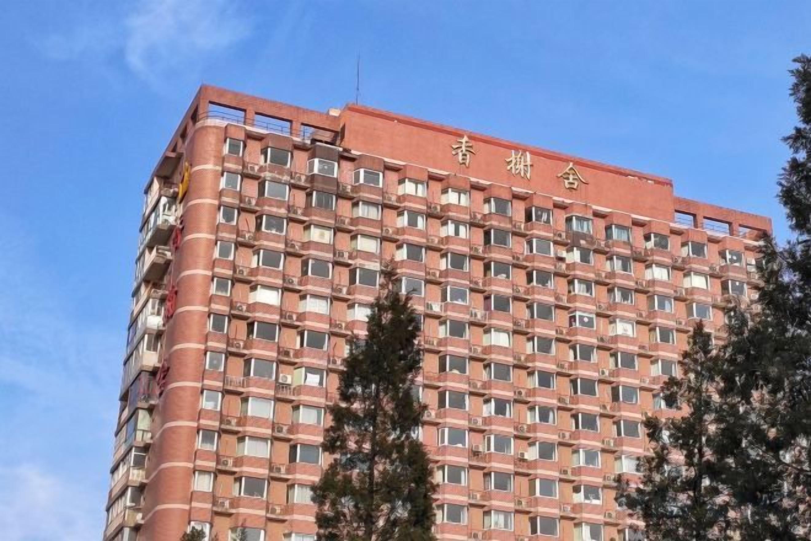 A multi-story building with a red facade and numerous windows.