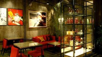A restaurant with a glass display case, red seating, and artwork on the walls.