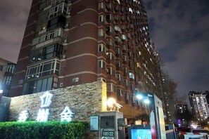 Un edificio alto con fachada de piedra y numerosas ventanas.