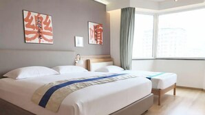 A hotel room with a large bed, a bedside table, a window with curtains, and two wall-mounted artworks. - Beijing Champs-Elysees Hotel (Panjiayuan Shilihe Subway Station) (Beijing)