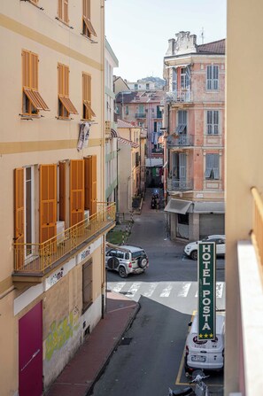 A narrow street with buildings on either side, a parked car, and a visible hotel sign. - Hotel 3 Comfort and Serenity Heart of Ventimiglia (Ventimiglia)