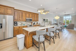 Une cuisine moderne avec des meubles en bois, des appareils en acier inoxydable et un îlot central doté de tabourets de bar.